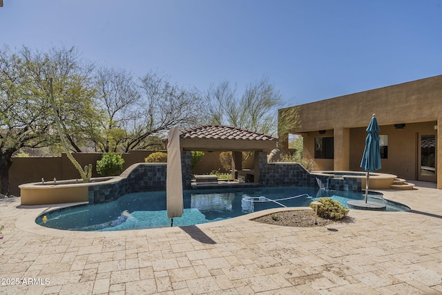 pool featuring an in ground hot tub, a patio area, and fence