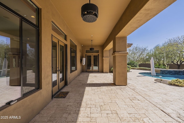 view of patio / terrace featuring an outdoor pool, a ceiling fan, and french doors