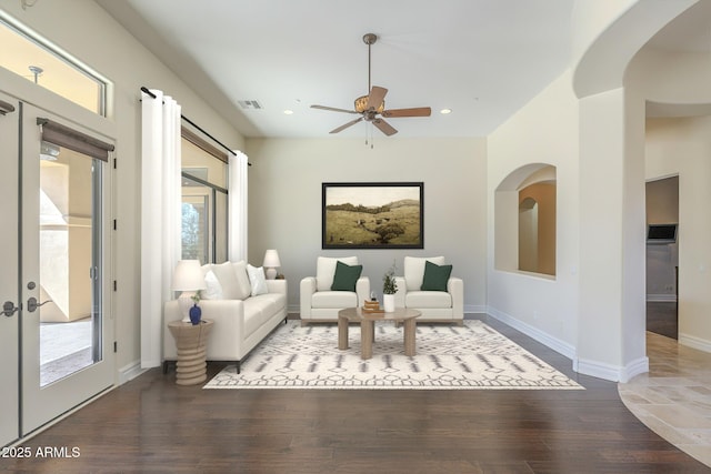 living room with a wealth of natural light, visible vents, and wood finished floors