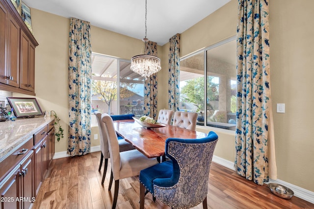 dining space featuring a notable chandelier and light wood-type flooring