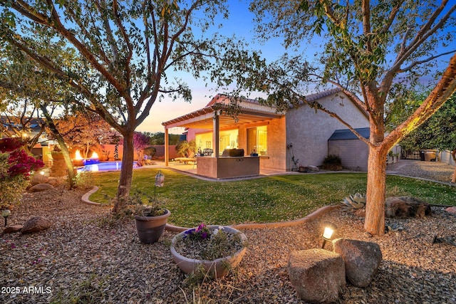 yard at dusk featuring a patio area and area for grilling