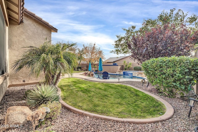 view of yard featuring a pool with hot tub