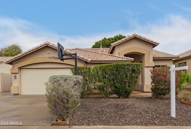 mediterranean / spanish-style home featuring a tile roof, driveway, an attached garage, and stucco siding