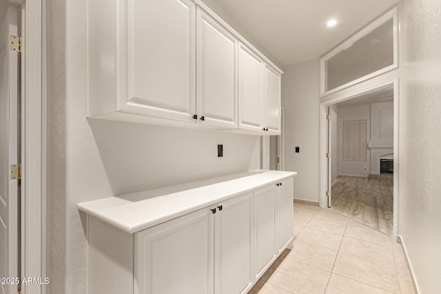 corridor with baseboards and light tile patterned floors