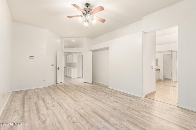 spare room featuring light wood-style flooring, baseboards, and a ceiling fan