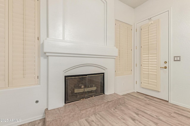 details with wood finished floors and a glass covered fireplace