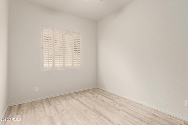 empty room featuring baseboards and wood finished floors