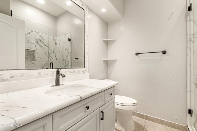 bathroom with vanity, a marble finish shower, toilet, and baseboards