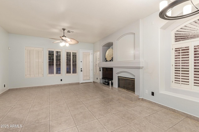 unfurnished living room featuring light tile patterned floors, visible vents, a fireplace, and a ceiling fan