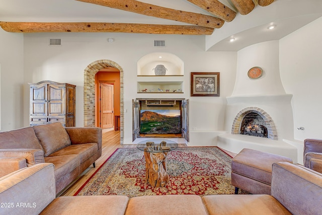 9415 N 124th St, Scottsdale, AZ 85259 - living room featuring a large fireplace, beam ceiling, wood finished floors, recessed lighting, and arched walkways