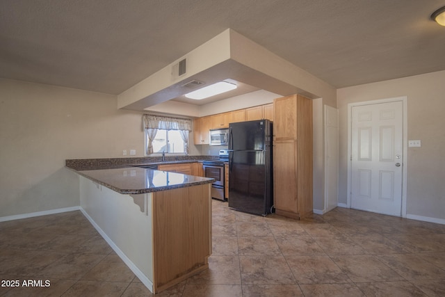 kitchen featuring a peninsula, visible vents, a kitchen bar, and appliances with stainless steel finishes