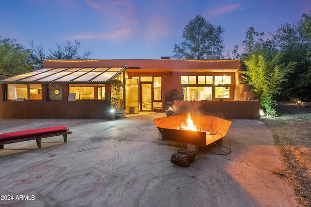 back house at dusk with a patio