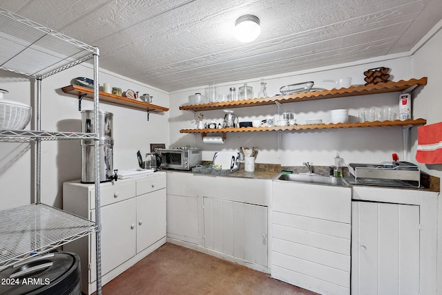 kitchen featuring carpet floors, white cabinets, and sink