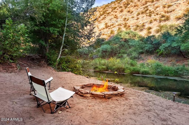 view of yard featuring a fire pit and a water view