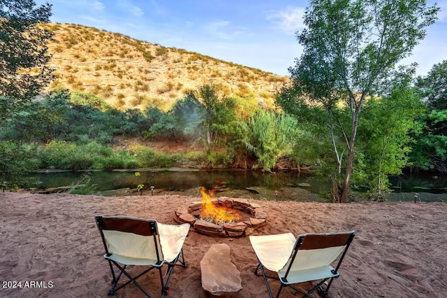 view of patio with a water and mountain view and a fire pit