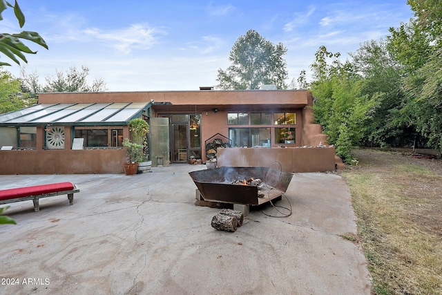 back of house with a patio and a fire pit