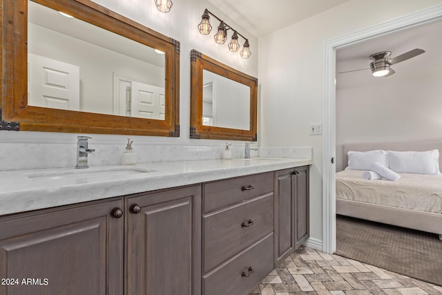 full bath with double vanity, baseboards, and a sink