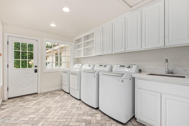 laundry area featuring washer and clothes dryer, a sink, recessed lighting, cabinet space, and baseboards