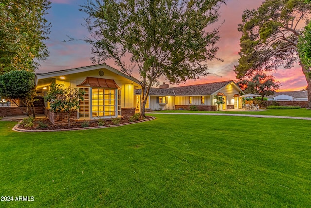 single story home with brick siding, board and batten siding, and a front lawn