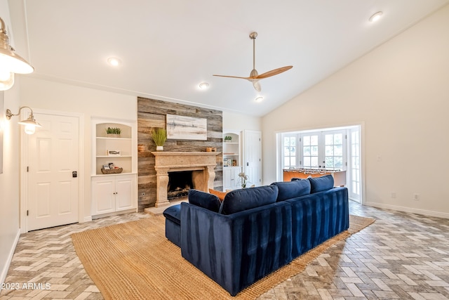 living room featuring a fireplace, built in shelves, a ceiling fan, and baseboards