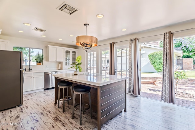 kitchen with a sink, stainless steel appliances, visible vents, and light countertops