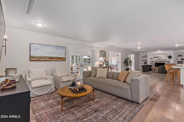 living room featuring visible vents, ornamental molding, french doors, a fireplace, and wood finished floors