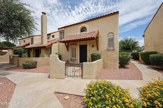 6533 N 7th Ave Unit 18, Phoenix, AZ 85013 - mediterranean / spanish-style home with a fenced front yard, a gate, stucco siding, and a tile roof
