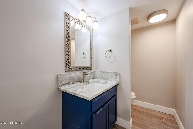 6533 N 7th Ave Unit 18, Phoenix, AZ 85013 - bathroom featuring vanity, toilet, wood finished floors, and baseboards