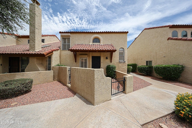6533 N 7th Ave Unit 18, Phoenix, AZ 85013 - mediterranean / spanish home featuring a gate, a fenced front yard, stucco siding, and a tile roof