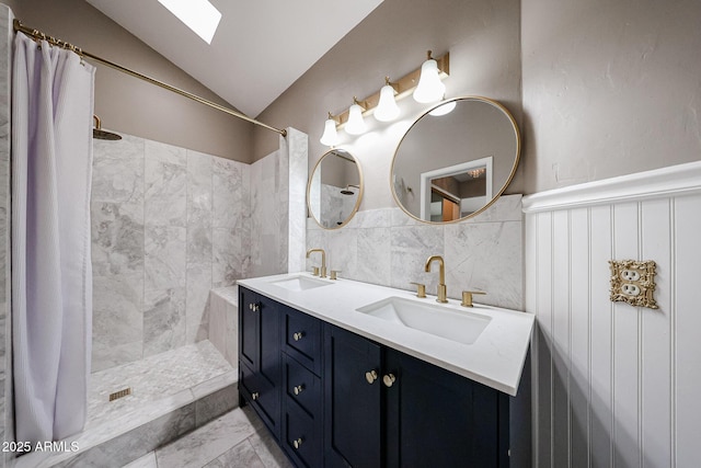6533 N 7th Ave Unit 18, Phoenix, AZ 85013 - full bathroom featuring tiled shower, double vanity, lofted ceiling, a skylight, and a wainscoted wall