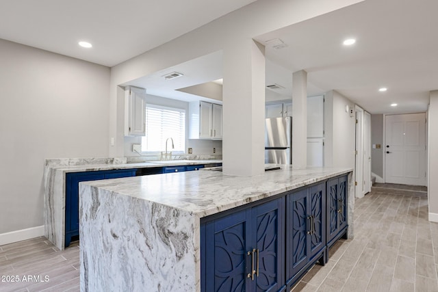 6533 N 7th Ave Unit 18, Phoenix, AZ 85013 - kitchen featuring freestanding refrigerator, blue cabinetry, a sink, light wood-style flooring, and recessed lighting