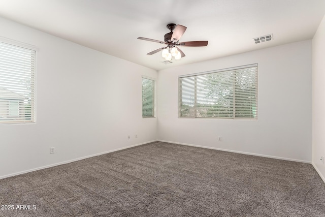 carpeted empty room featuring plenty of natural light, a ceiling fan, and baseboards