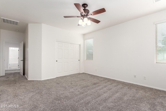 unfurnished bedroom with carpet floors, baseboards, a closet, and ceiling fan