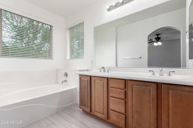 full bathroom with a ceiling fan, a bath, and double vanity