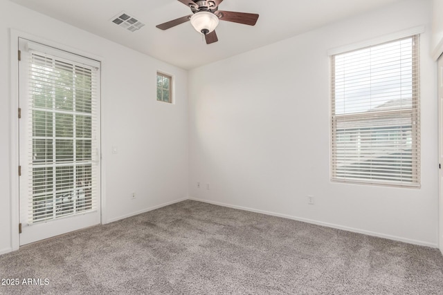 carpeted empty room featuring ceiling fan and baseboards