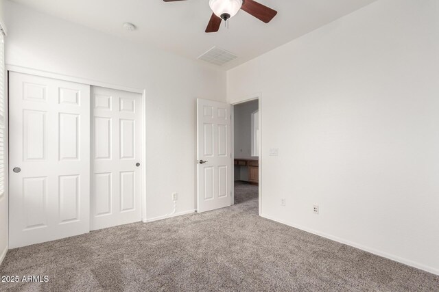 unfurnished bedroom featuring carpet flooring, a closet, baseboards, and a ceiling fan