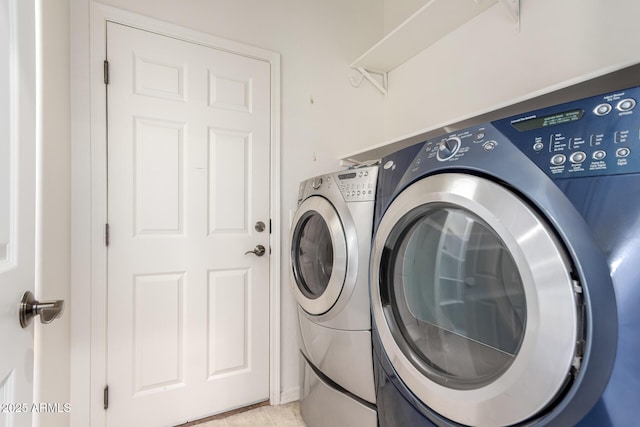 clothes washing area with washing machine and dryer