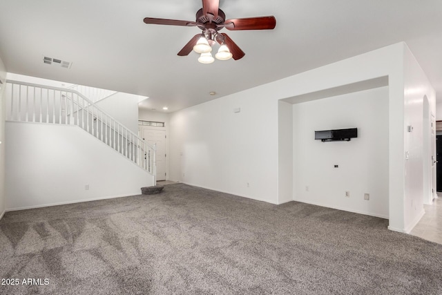 unfurnished living room featuring carpet flooring, a ceiling fan, stairway, and baseboards