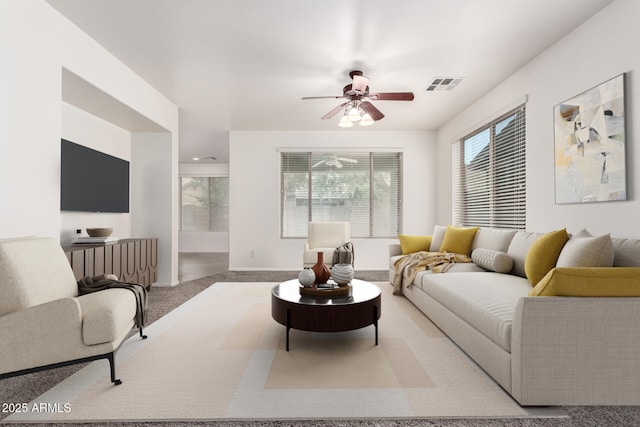 living area featuring a ceiling fan, carpet floors, and baseboards