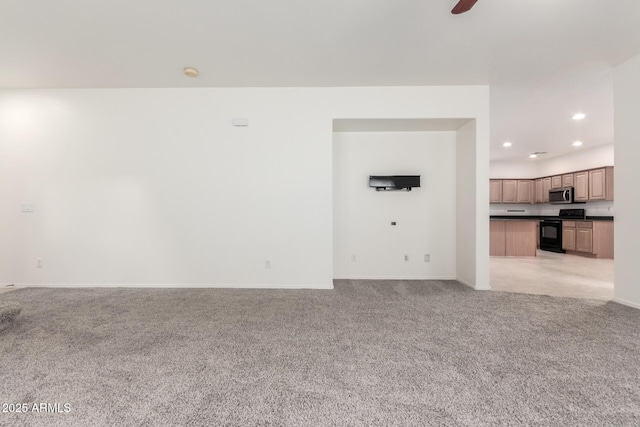 unfurnished living room featuring light colored carpet, recessed lighting, baseboards, and a ceiling fan