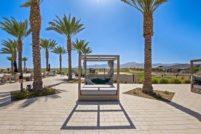 view of property's community with a mountain view and a patio area