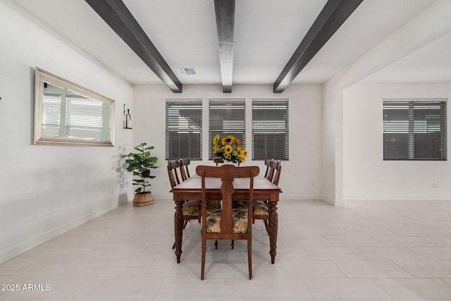 dining space featuring beamed ceiling