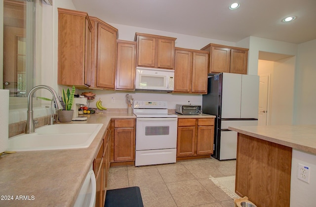 kitchen with sink, light tile patterned floors, and white appliances