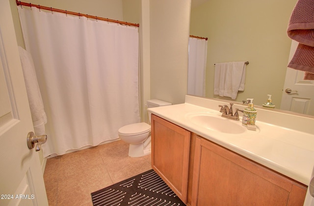 bathroom with tile patterned flooring, vanity, and toilet