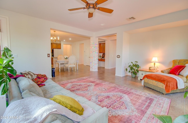 living room featuring ceiling fan with notable chandelier