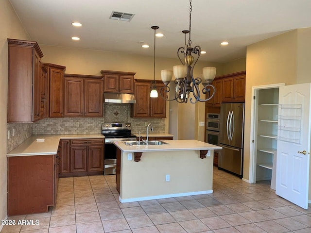 kitchen with tasteful backsplash, an island with sink, appliances with stainless steel finishes, and light tile patterned floors