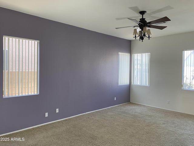 unfurnished room with ceiling fan, a healthy amount of sunlight, and carpet flooring