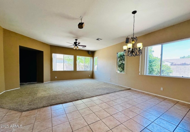 tiled empty room with ceiling fan with notable chandelier