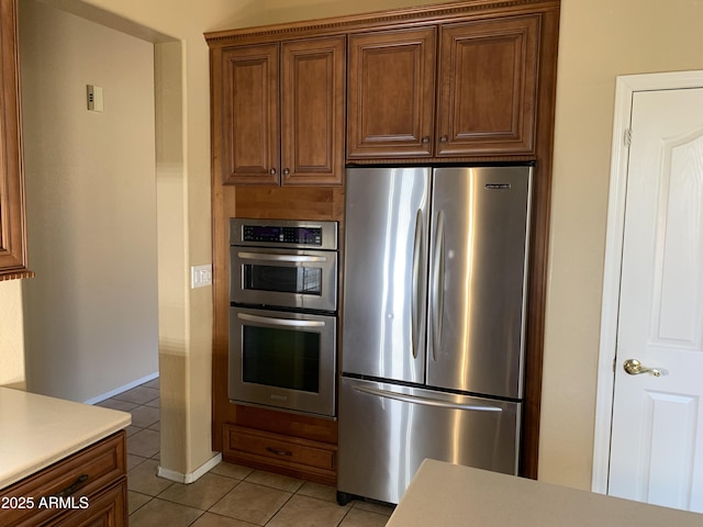 kitchen featuring stainless steel appliances and light tile patterned flooring