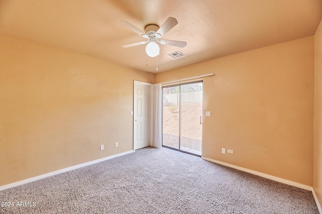 carpeted spare room featuring ceiling fan